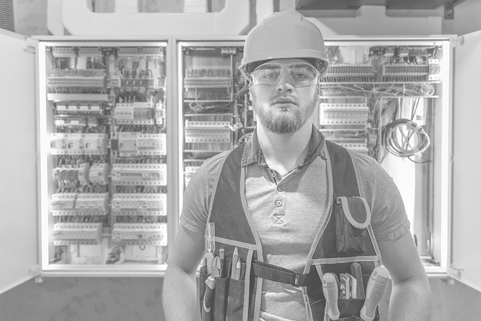 electrician man in overalls works in the switchboard. portrait of an electrician in overalls.